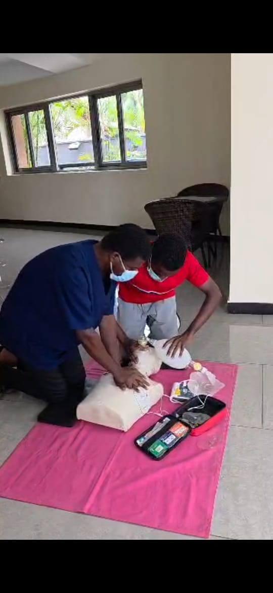 Participants practising CPR on a training mannequin during a COTA BLS session
